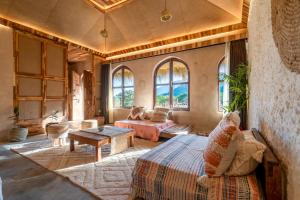 Sunanda by 1810AD - A Boutique Organic Retreat في بوشكار: غرفة نوم بسرير واريكة ونوافذ +71 صورة