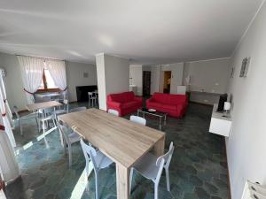 a living room with a wooden table and red chairs at Garnì Hotel Tignale in Tignale