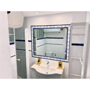 ein Badezimmer mit Waschbecken und Spiegel in der Unterkunft Helios II - Free Parking - By Lcdsol in Torremolinos