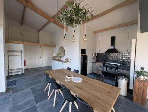 a large kitchen with a wooden table and chairs at d'Oude Smidse in Zuienkerke