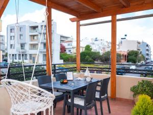 a patio with a table and chairs on a balcony at Cocomelo apts 3 luxury in Heraklio