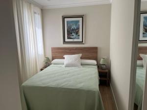 a bedroom with a bed with a green comforter at Mirador de Sanlucar 3 in Sanlúcar de Barrameda +17 photos