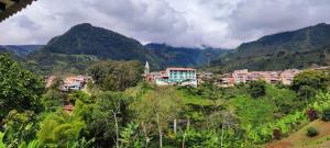 a town on a hill with mountains in the background at habitación campestre para pareja JAZMIN in Jardin