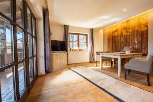 Una sala de estar con una mesa y un televisor. en Sonnenschein, en Garmisch-Partenkirchen