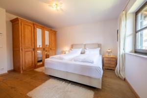 Un dormitorio con una gran cama blanca y una ventana. en Sonnenschein, en Garmisch-Partenkirchen