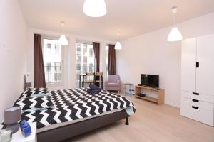 une chambre avec un lit noir et blanc et une télévision dans l'établissement Brussels center flat, à Bruxelles