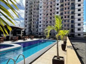 a swimming pool in front of a large building at Sinta-se em casa em um lar provisório e completo! in Aracaju
