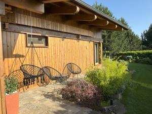 a patio with three chairs and a swing at Villa - VALL DI VALL in Pirin Golf & Country Club in Razlog