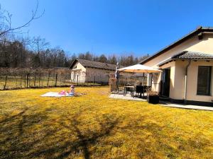 Un bambino seduto su una coperta in un giardino accanto a una casa di Luxuriöses, familienfreundliches Ferienhaus ,,Amy,, mit Whirlpoolwanne, Kamin und Garten a Hinterhausen