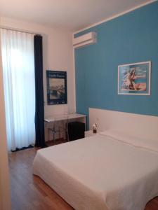a bedroom with a white bed and a blue wall at Bed and Breakfast VILLA ARANCIO Ghiffa in Ghiffa +23 photos