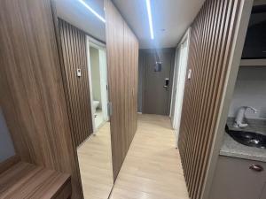 a hallway with mirrors in a bathroom with a sink at BLEND MARISTA! Compacto de Luxo no bairro mais nobre da cidade! in Goiânia