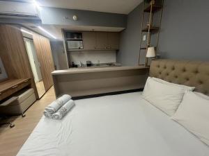 a bedroom with a large white bed and a kitchen at BLEND MARISTA! Compacto de Luxo no bairro mais nobre da cidade! in Goiânia