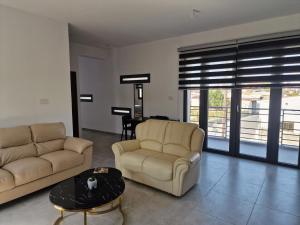 a living room with two couches and a table at George Apartments in Larnaca +12 photos