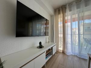 een woonkamer met een flatscreen-tv aan de muur bij SATORI Romantyczny azyl dla dwojga 150 m od plaży - apartament z balkonem i parkingiem, Playa de Gandia in Playa de Gandia