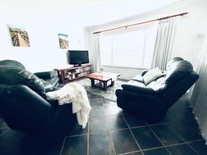 a living room with two couches and a tv at Troon Retreat! Golf, Wineries, beaches in Dunsborough