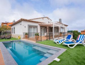 una casa con piscina y 2 sillas de césped en Casa Adela, en Begur
