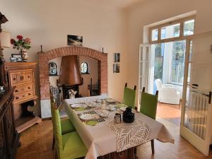 a dining room with a table and green chairs at B&B Le Colombine in Abbadia Lariana