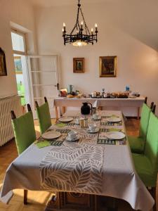 a dining room with a table and green chairs at B&B Le Colombine in Abbadia Lariana +30 photos