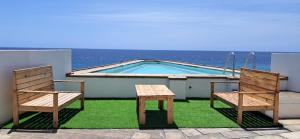 due sedie e un tavolo accanto a una piscina di Cacimba Sunset Lodge a Tarrafal