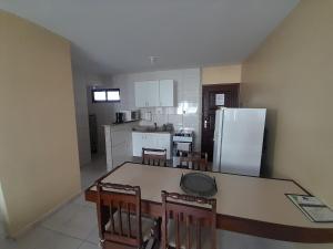 a kitchen with a table and chairs and a refrigerator at Barra Apart in Salvador