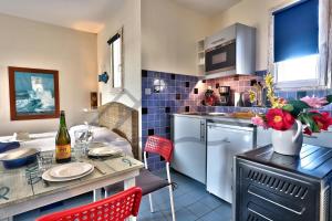 eine Küche mit Theke und einem Tisch mit roten Stühlen in der Unterkunft LocaLise - B80 - La villa Blanche - L'iroise - 1er étage plain pied - Wifi inclus - Draps inclus - Animaux bienvenues in Le Guilvinec