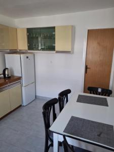 a kitchen with a table and chairs and a refrigerator at Edo Apartman 1 in Senj +4 photos