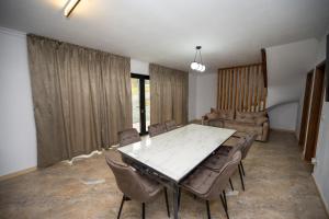 a dining room with a table and chairs at EDEN HOUSE Viseu de Sus in Vişeu de Sus