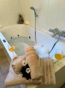 una vasca da bagno con 2 bicchieri di vino e un asciugamano di Luxuriöses, familienfreundliches Ferienhaus ,,Amy,, mit Whirlpoolwanne, Kamin und Garten a Hinterhausen Altre 54 foto