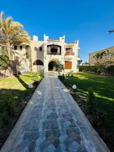 a stone walkway leading to a large house at Villa in marina 5 - First Row Lake View in El Alamein