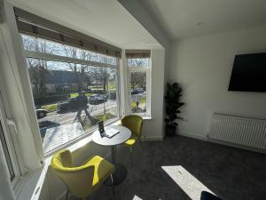 a living room with a table and chairs and a large window at Park view holiday apartment in Skegness