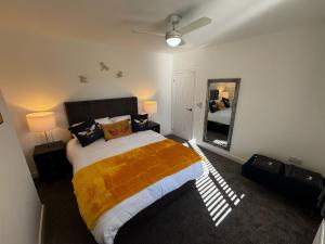a bedroom with a large bed and a mirror at Park view holiday apartment in Skegness