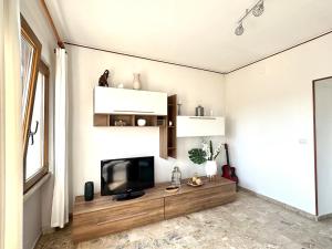 a living room with a flat screen tv on a wooden table at Il portico del Lago in Varese +11 photos
