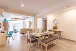 a kitchen and dining room with a table and chairs at Condo at Icono 3 Bedrooms close 5th in Playa del Carmen