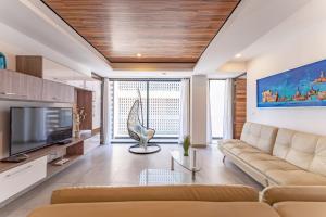 a living room with a couch and a television at Bright and nice 3 Beds close to 5th in Playa del Carmen