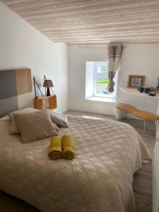 a bedroom with a large bed with two yellow slippers on it at Chez Isabelle et Johann in Angliers