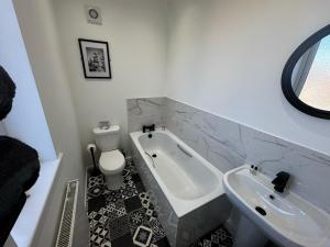 a bathroom with a tub and a toilet and a sink at Park view holiday apartment in Skegness +15 photos