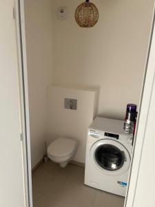 a bathroom with a washing machine and a toilet at Le spot in Camiers