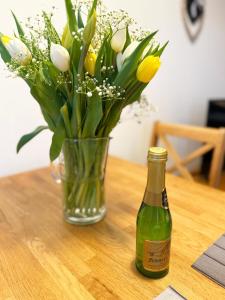 un vase de fleurs et une bouteille sur une table dans l'établissement Strandläufer, à Burgtiefe auf Fehmarn 