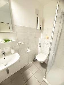 une salle de bains blanche avec toilettes et lavabo dans l'établissement Strandläufer, à Burgtiefe auf Fehmarn 