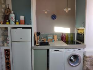 eine Küche mit einem weißen Kühlschrank und einem Geschirrspüler in der Unterkunft Maison avec jardin au coeur du village in Ampus