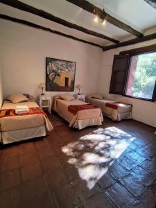 a bedroom with two beds and a large window at TADASANA CASA DE CAMPO in La Carrera +37 photos