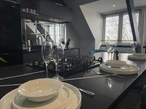 a kitchen with glasses and plates on a counter at ResiLets - The Monopoly Apartment - Large 4 bedroom in Bedlington