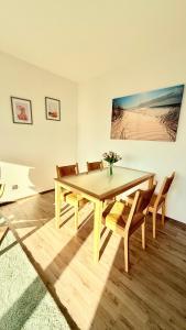 Un comedor con mesa y sillas de madera. en Panorama Lodge, en Salzgitter