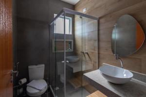 a bathroom with a sink and a glass shower at Villa Orion in Arraial do Cabo