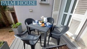 a table and four chairs on a porch with a table and a table at Palm House in Brusimpiano +4 photos