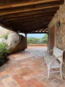 a patio with a bench under a wooden roof at Apartment La Capitaneria in Porto Cervo