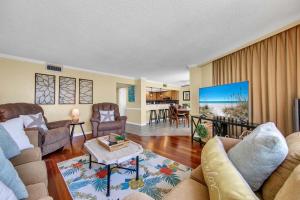 a living room with two couches and a kitchen at Edgewater Tower 1-411 in Panama City Beach