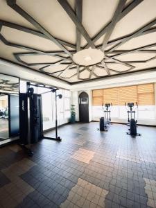 a gym with treadmills and elliptical machines at JFam Suites Allegra Condo with Balcony, FREE Parking in Manila