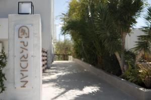 a sign for the entrance to a building with palm trees at Paridian Elegant Living in Parikia