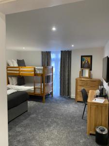 a bedroom with two bunk beds and a desk at Carlton Hotel in Ilfracombe